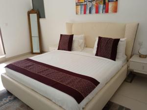 ein Schlafzimmer mit einem großen Bett in Braun- und Weißtönen in der Unterkunft Sifah Inn in As Sīfah