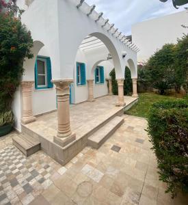 馬赫迪耶的住宿－Dar Set El Kol, Résidence de charme à Mahdia，一座带拱门和楼梯的房屋的庭院