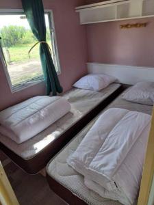 two bunk beds in a room with a window at Camping La Maltournée in Sigloy
