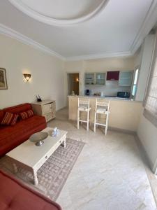 een woonkamer met een rode bank en een tafel bij Dar Set El Kol, Résidence de charme à Mahdia in Mahdia