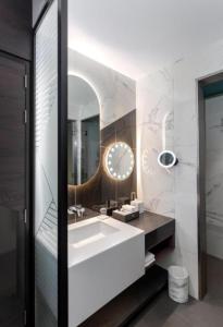 La salle de bains est pourvue d'un lavabo blanc et d'un miroir. dans l'établissement Hyatt Centric Jumeirah - King Room Skyline - UAE, à Dubaï