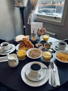 a table topped with plates of food and cups of coffee at My Place Hotel in London