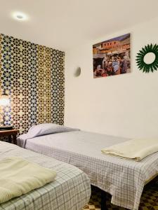Cette chambre comprend 2 lits et une photo murale. dans l'établissement Casa Lucas, à Tetouan