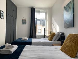 a hotel room with two beds and a window at Cheerful - 3 Bed - Serviced Accommodation - In Heart of Northumberland - Sleeps 6 in Bebside