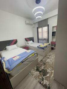 een kamer met 2 bedden en een raam bij Madinaty Apartment in Madinaty