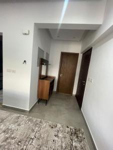 een lege kamer met een houten deur en een hal bij Madinaty Apartment in Madinaty
