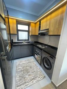 een keuken met een wasmachine en een wastafel bij Madinaty Apartment in Madinaty