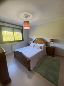 1 dormitorio con cama y ventana grande en CASA LOS CEREZOS, en Arbo