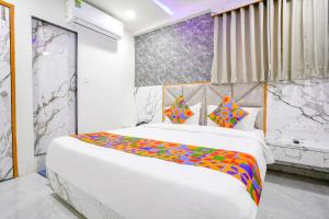 una camera da letto con un grande letto bianco con una coperta colorata di FabHotel Sun View a Ahmedabad