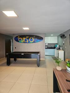 a piano in a room with a surfboard on the wall at Surf'O Hostel in Rio de Janeiro