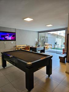 a pool table in a room with a tv at Surf'O Hostel in Rio de Janeiro