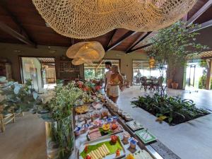 two people standing in a room with a buffet of food at Hotel Ponta do Madeiro in Pipa