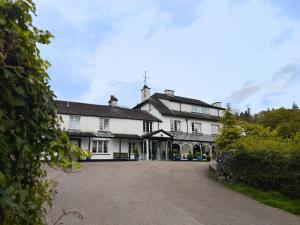 een groot wit huis met een grote oprit bij Skelwith Bridge Hotel in Ambleside