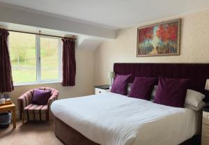 - une chambre avec un grand lit et une fenêtre dans l'établissement Skelwith Bridge Hotel, à Ambleside