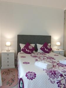 a bedroom with a bed with purple and purple pillows at Casa Talika in Fátima +32 photos