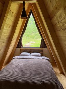 Šavnik的住宿－Natures Escape Kozarica，一张位于带大窗户的帐篷内的床铺