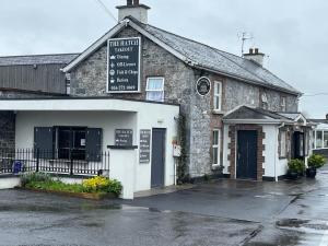 an old stone building with a sign on it at Glendine Inn in Kilkenny