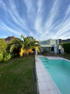 a house with a swimming pool and a palm tree at Cabaña privada en Valle Grande San Rafael in Valle Grande