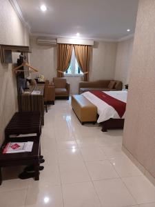 Habitación de hotel con cama y sala de estar. en 3 Putra BI Executive Hotel Jakarta en Yakarta