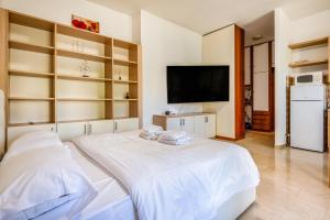 una camera con un grande letto bianco e una TV a schermo piatto di Milano 3PAX WIFI- Via Tosi a Milano