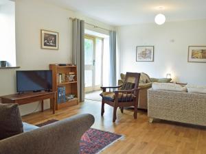 a living room with a couch and a tv at Lower Barn in Pencader