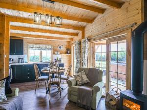 a living room with a fireplace in a log cabin at Stable Lodge At Greenacre in Bromyard