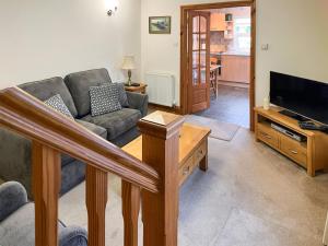 a living room with a couch and a television at Elens Place in Tywyn