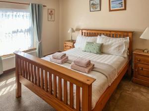 a bedroom with a large bed with towels on it at Elens Place in Tywyn