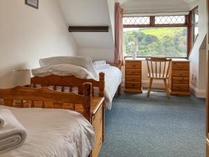 a bedroom with two beds and a desk and a window at Marine Mews 3 in Salcombe