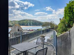 a balcony with a table and chairs and a view of a river at Marine Mews 3 in Salcombe