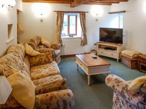 ein Wohnzimmer mit Sofas und einem Flachbild-TV in der Unterkunft Howards End in Leysters