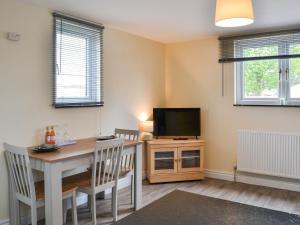 a dining room with a table and a television at Lanburnum Lodge - Uk47076 in Wilberfoss