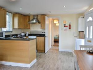 a kitchen with wooden cabinets and black counter tops at Lanburnum Lodge - Uk47076 in Wilberfoss