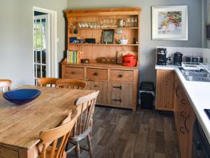 - une cuisine avec une table en bois et des placards en bois dans l'établissement Heath View, à Saxmundham