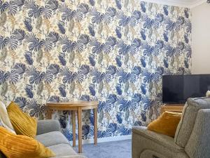 a living room with a blue and white wallpaper at The Hideaway in Crieff