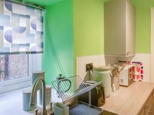 a kitchen with green walls and a sink at The Hideaway in Crieff