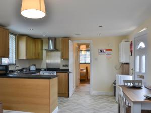 a kitchen with wooden cabinets and a counter top at Pine Lodge - Uk47075 in Wilberfoss