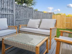 a patio with two chairs and a table and a fence at Queen House in Belper