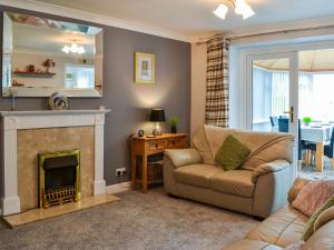 a living room with a couch and a fireplace at Garden Cottage in Nafferton