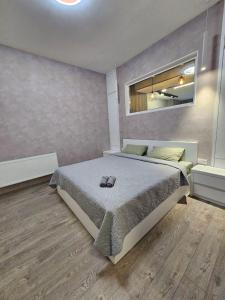 a bedroom with a large bed and a mirror at Centre Apartment in Gyumri