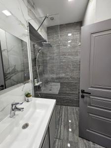 a bathroom with a white sink and a shower at Centre Apartment in Gyumri