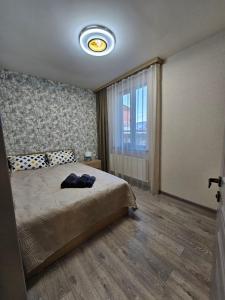 a bedroom with a bed and a large window at Centre Apartment in Gyumri
