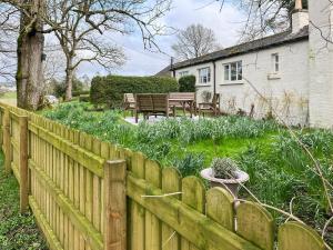 a wooden fence in front of a house at Milnhead Cottage in Amisfield Town