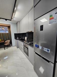 a kitchen with a stainless steel refrigerator and a table at Centre Apartment in Gyumri