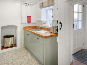 a kitchen with a sink and a counter top at Rectory Cottage - Uk46995 in Overstrand