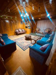 a living room with blue couches and a table at Abshar Heritage Villa in Srinagar