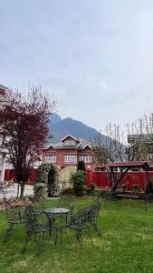 a group of benches and a table in a yard at Abshar Heritage Villa in Srinagar