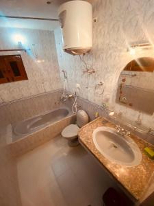 a bathroom with a sink and a tub and a toilet at Abshar Heritage Villa in Srinagar