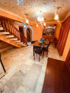 a dining room with a table and chairs and a staircase at Abshar Heritage Villa in Srinagar