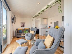 uma sala de estar com cadeiras azuis e uma mesa em Galloway Ewe - Uk46819 em Wigtown